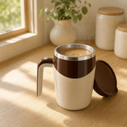 Cream & coffee self-stirring mug on a kitchen counter with a latte swirling